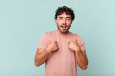 İspanyol yakışıklı adam mutlu, şaşkın ve gururlu, heyecanlı, şaşkın bakışlarıyla kendini işaret ediyor.