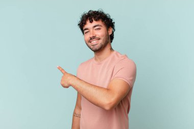 İspanyol yakışıklı adam heyecanlı ve şaşırmış görünüyor. Yana ve yukarı doğru uzayı gösteriyor.