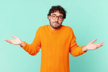 İspanyol yakışıklı adam şaşkın ve şaşkın, şüpheci, farklı seçenekleri tartıyor ya da komik bir ifadeyle seçiyor.