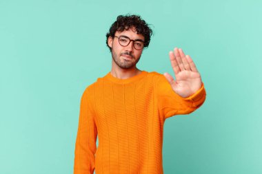 İspanyol yakışıklı adam ciddi, sert, hoşnutsuz ve kızgın görünüyor. Avuç içinin açık olması jesti durduruyor.