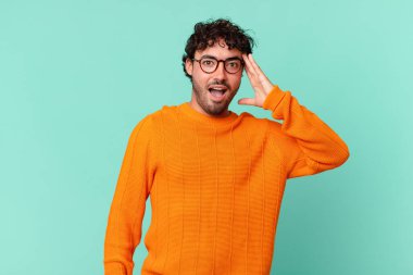 İspanyol yakışıklı adam mutlu, şaşkın ve şaşırmış görünüyor, gülümsüyor ve inanılmaz ve inanılmaz iyi haberleri fark ediyor.