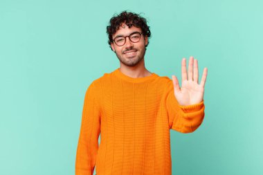 İspanyol yakışıklı adam mutlu ve neşeyle gülümsüyor, el sallıyor, seni selamlıyor ya da veda ediyor.