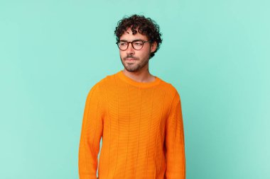 Hispanik yakışıklı adam üzgün, üzgün ya da kızgın ve olumsuz bir tutum içinde, anlaşmazlık içinde somurtuyor.