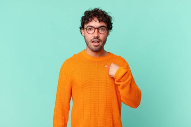 Şok olmuş ve ağzı açık, kendini işaret eden İspanyol yakışıklı bir adam.