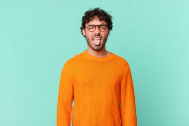 İspanyol yakışıklı adam tiksinmiş ve rahatsız olmuş hissediyor, dilini dışarı çıkarıyor, iğrenç ve iğrenç bir şeyden hoşlanmıyor.