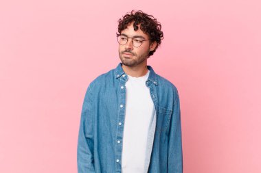 Hispanik yakışıklı adam üzgün, üzgün ya da kızgın ve olumsuz bir tutum içinde, anlaşmazlık içinde somurtuyor.