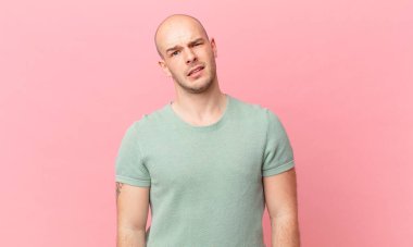 bald man feeling puzzled and confused, with a dumb, stunned expression looking at something unexpected