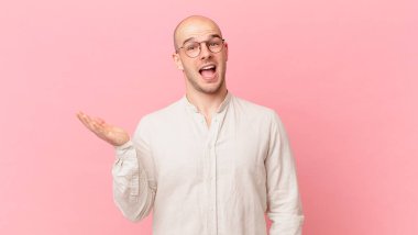 Kel adam mutlu, şaşkın ve neşeli, pozitif bir tavırla gülümseyen, bir çözüm ya da fikir gerçekleştiren