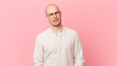 bald man feeling puzzled and confused, with a dumb, stunned expression looking at something unexpected