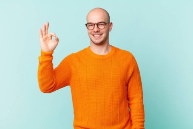 Kel adam mutlu, rahat ve tatmin olmuş hissediyor. Onayını iyi bir hareketle gösteriyor. Gülümsüyor.