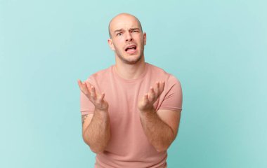 Kel adam umutsuz ve sinirli görünüyor, stresli, mutsuz ve sinirli, bağırıyor ve çığlık atıyor.