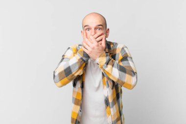 Kel adam elleri ile ağzını kapatıyor, şok olmuş, şaşırmış bir ifadeyle, sır saklıyor ya da 