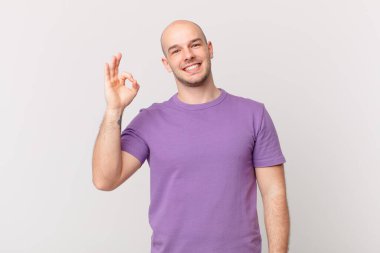 Kel adam mutlu, rahat ve tatmin olmuş hissediyor. Onayını iyi bir hareketle gösteriyor. Gülümsüyor.