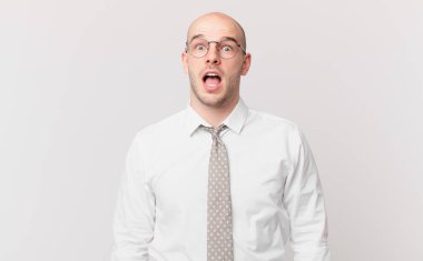 Kel iş adamı şaşırmış ya da şok olmuş görünüyor, ağzı açık bir şekilde 