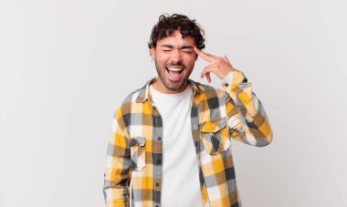 İspanyol yakışıklı adam mutsuz ve stresli görünüyor, intihar jesti elle silah işareti yapıyor, kafasını işaret ediyor.