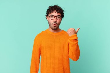 İspanyol asıllı yakışıklı adam inançsızlıktan şaşkın şaşkın bakıyor, yan taraftaki objeyi işaret ediyor ve diyor ki: