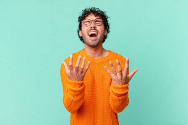 İspanyol yakışıklı adam umutsuz ve hayal kırıklığına uğramış görünüyor, stresli, mutsuz ve sinirli, bağırıyor ve çığlık atıyor.