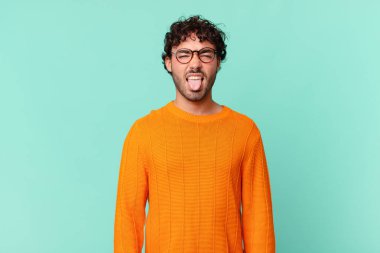 İspanyol yakışıklı adam tiksinmiş ve rahatsız olmuş hissediyor, dilini dışarı çıkarıyor, iğrenç ve iğrenç bir şeyden hoşlanmıyor.