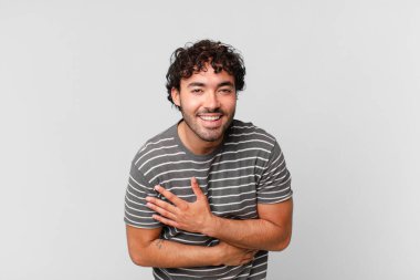 İspanyol yakışıklı adam komik bir şakaya yüksek sesle gülüyor, mutlu ve neşeli hissediyor, eğleniyor.