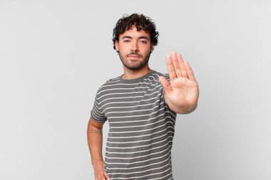 İspanyol yakışıklı adam ciddi, sert, hoşnutsuz ve kızgın görünüyor. Avuç içinin açık olması jesti durduruyor.