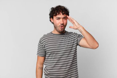 İspanyol yakışıklı adam mutlu, şaşkın ve şaşırmış görünüyor, gülümsüyor ve inanılmaz ve inanılmaz iyi haberleri fark ediyor.