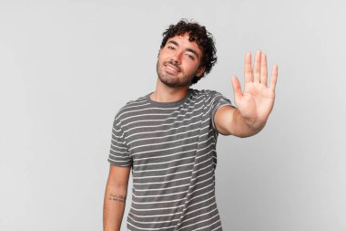 İspanyol yakışıklı adam mutlu ve neşeyle gülümsüyor, el sallıyor, seni selamlıyor ya da veda ediyor.