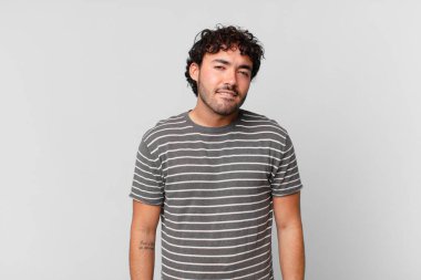 İspanyol yakışıklı adam şaşkın ve şaşkın görünüyor. Sinirli bir hareketle dudağını ısırıyor. Sorunun cevabını bilmiyor.