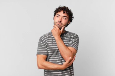 İspanyol yakışıklı düşünen, kuşkulu ve kafası karışık, farklı seçenekleri olan, hangi kararı vereceğini merak eden bir adam.