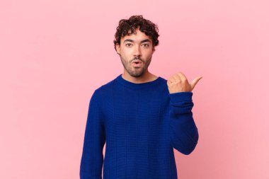 İspanyol asıllı yakışıklı adam inançsızlıktan şaşkın şaşkın bakıyor, yan taraftaki objeyi işaret ediyor ve diyor ki: