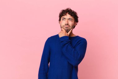 İspanyol yakışıklı düşünen, kuşkulu ve kafası karışık, farklı seçenekleri olan, hangi kararı vereceğini merak eden bir adam.