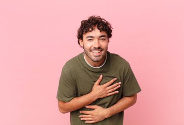 İspanyol yakışıklı adam komik bir şakaya yüksek sesle gülüyor, mutlu ve neşeli hissediyor, eğleniyor.