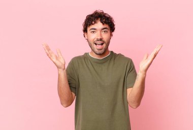 İspanyol yakışıklı adam mutlu, heyecanlı, şaşırmış ya da şok olmuş, gülümseyen ve hayrete düşmüş hissediyor.