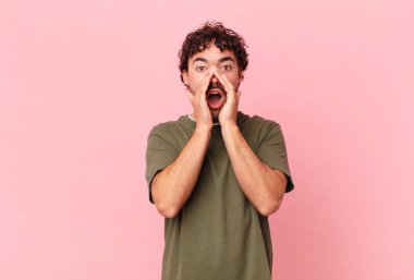 İspanyol yakışıklı adam mutlu, heyecanlı ve pozitif hissediyor. Elleri ağızda, bağırıyor.