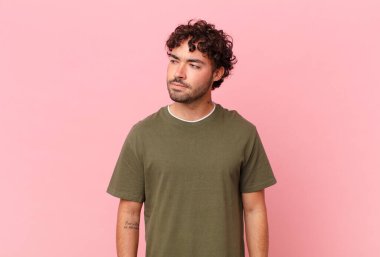 Hispanik yakışıklı adam üzgün, üzgün ya da kızgın ve olumsuz bir tutum içinde, anlaşmazlık içinde somurtuyor.