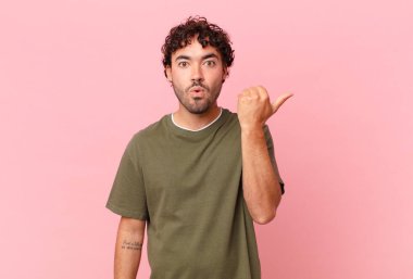 İspanyol asıllı yakışıklı adam inançsızlıktan şaşkın şaşkın bakıyor, yan taraftaki objeyi işaret ediyor ve diyor ki: