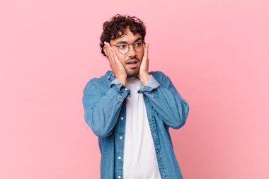 Hispanik yakışıklı adam mutlu, heyecanlı ve şaşırmış hissediyor, iki eli yüzü yana bakıyor