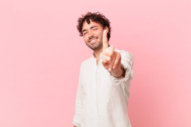 İspanyol yakışıklı adam gururla gülümsüyor ve gururla bir numaralı poz veriyor, kendini lider gibi hissediyor.