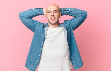 Kel adam kendini stresli, endişeli, endişeli ya da korkmuş hissediyor, elleri başının üstünde, hata yaptığında panikliyor.