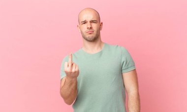 Kel adam kızgın, sinirli, asi ve agresif hissediyor, orta parmağını sallıyor, karşı koyuyor.