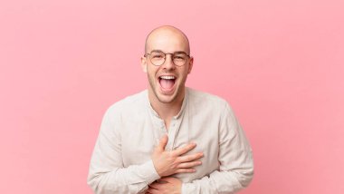 Kel adam komik bir şakaya gülüyor, mutlu ve neşeli hissediyor, eğleniyor.