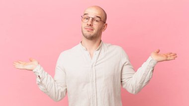 Kel adam şaşkın ve kafası karışık, şüpheci, farklı seçenekleri tartıyor ya da komik bir ifadeyle seçiyor