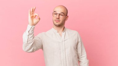 Kel adam mutlu, rahat ve tatmin olmuş hissediyor. Onayını iyi bir hareketle gösteriyor. Gülümsüyor.