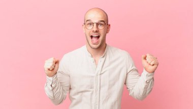 Kel adam şaşkın, heyecanlı ve mutlu hissediyor, gülüyor ve başarıyı kutluyor,!