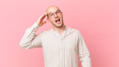 Kel adam mutlu, şaşkın ve şaşırmış görünüyor, gülümsüyor ve inanılmaz ve inanılmaz iyi haberleri fark ediyor.