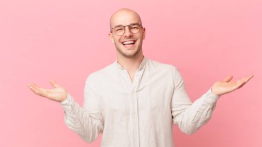 Kel adam mutlu, heyecanlı, şaşırmış ya da şok olmuş hissediyor, gülümsüyor ve inanılmaz bir şeye şaşırıyor.