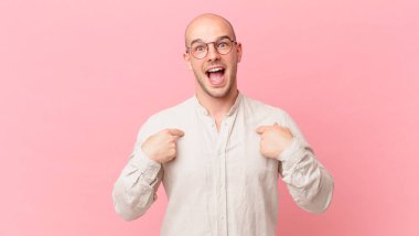 Kel adam mutlu, şaşırmış ve gururlu hissediyor. Heyecanlı ve şaşkın bir bakışla kendini işaret ediyor.