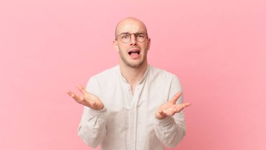 Kel adam umutsuz ve sinirli görünüyor, stresli, mutsuz ve sinirli, bağırıyor ve çığlık atıyor.