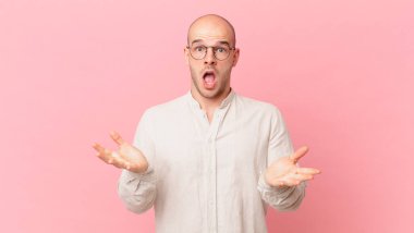 Kel adam son derece şok olmuş ve şaşırmış, endişeli ve panik içinde, stresli ve dehşete düşmüş bir bakışla