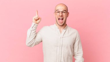 Bir fikri fark ettikten sonra mutlu ve heyecanlı bir dahi gibi hisseden kel bir adam, neşeli bir şekilde parmağını kaldırıyor, eureka!