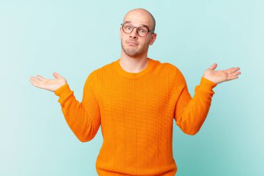 Kel adam şaşkın ve kafası karışık, şüpheci, farklı seçenekleri tartıyor ya da komik bir ifadeyle seçiyor